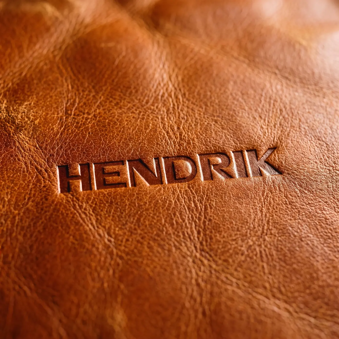 The HENDRIK maker's mark blind-debossed into full-grain cognac leather